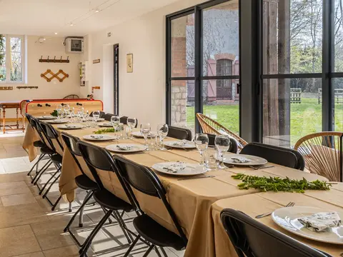 Salle à manger lumineuse du gîte de groupe avec table dressée
