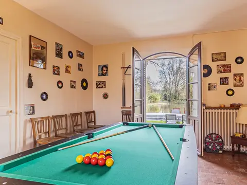 Salle billard avec vue sur l’étang dans le gîte de groupe