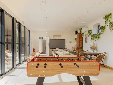 Pièce à vivre climatisée avec baby-foot et grande table pour 18 personnes