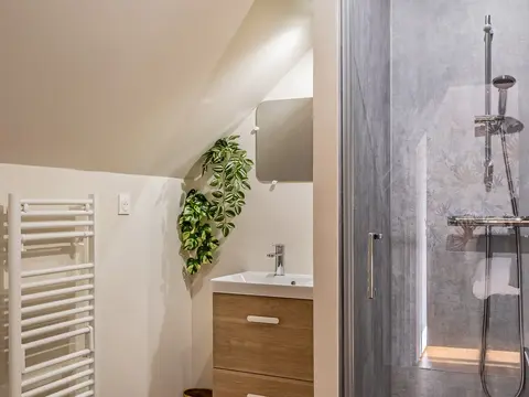 Salle d’eau de la suite Pic Épeiche avec douche, vasque et sèche-serviettes